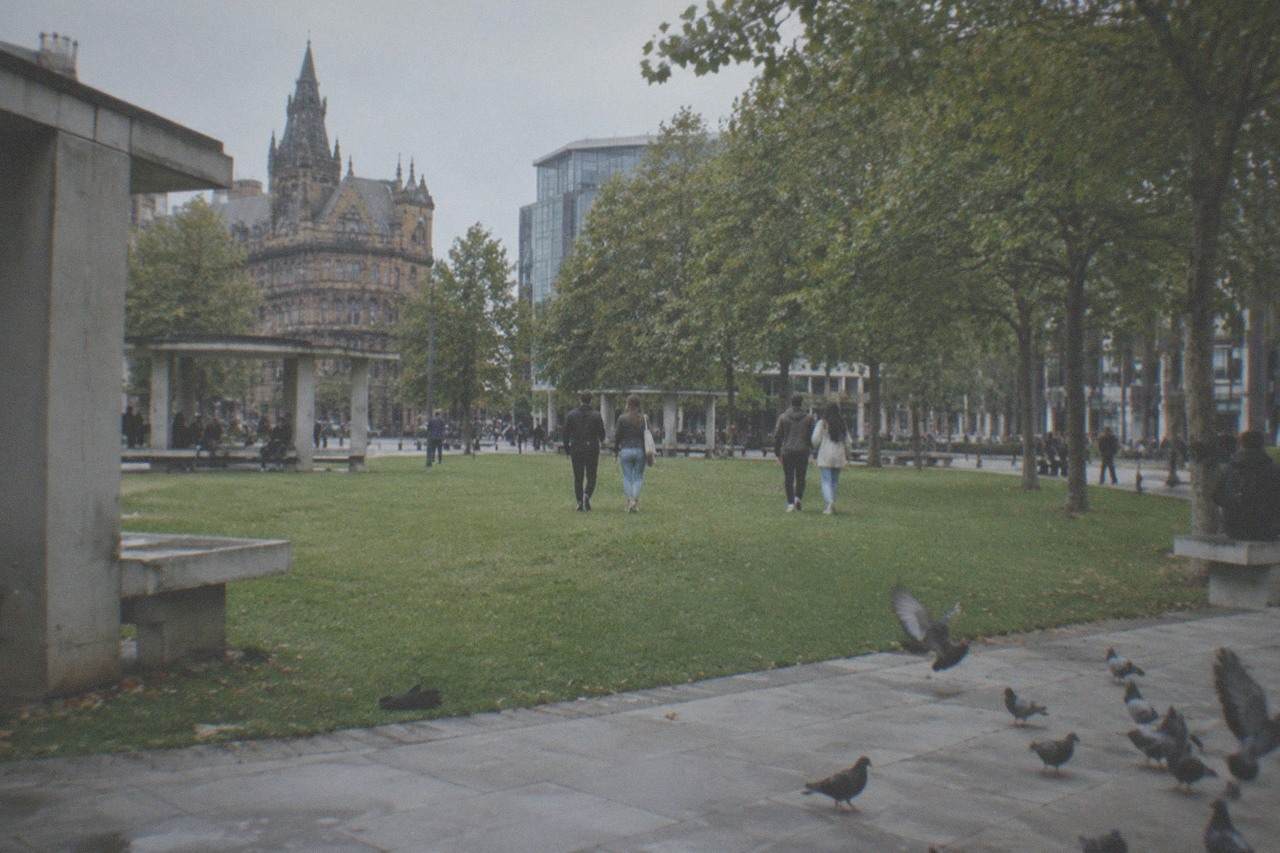 Visitors walking through Piccadilly Gardens in central Manchester on a bright weekend afternoon