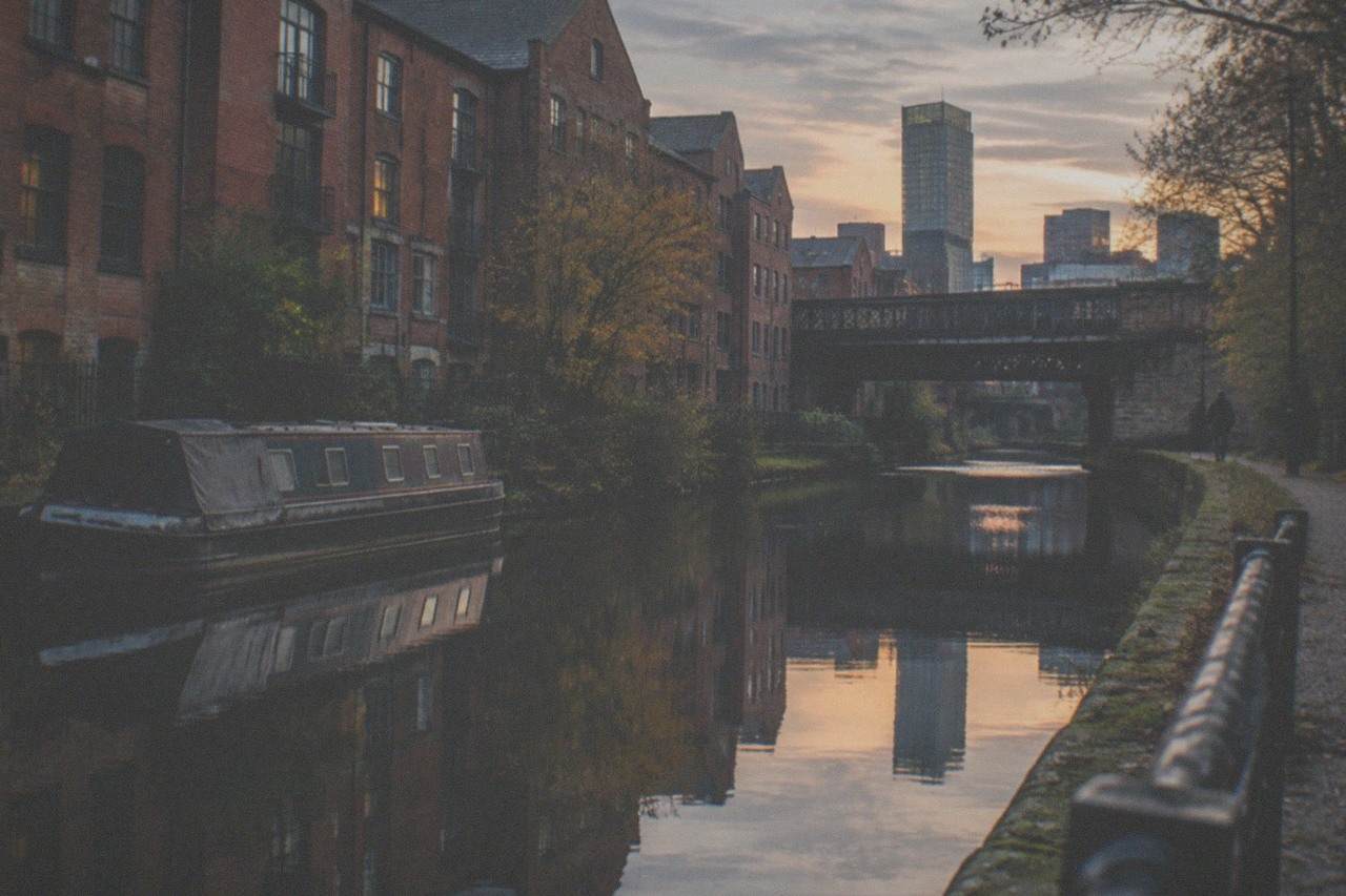 The Rochdale Canal towpath running through central Manchester past brick warehouses